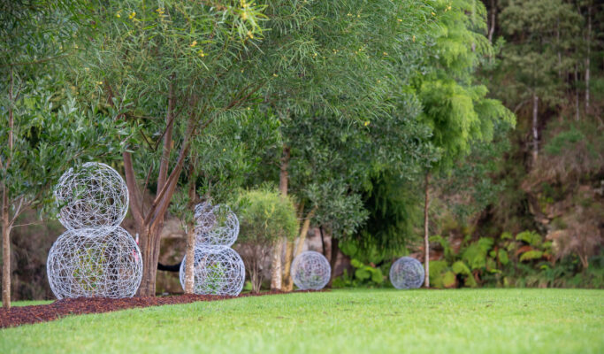 Wire sculptures places in the garden beds between native trees